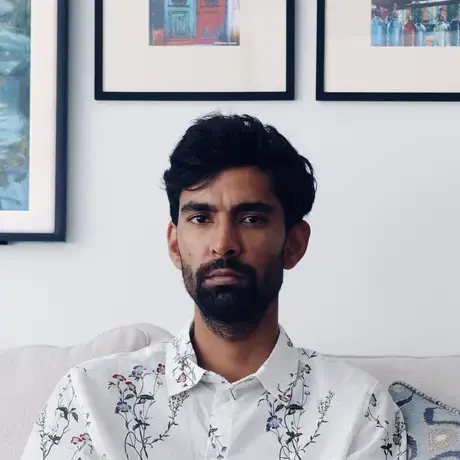 Headshot of Atul wearing a white printed button-down