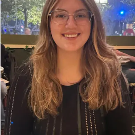 Headshot of Sarah wearing glasses and a black dress