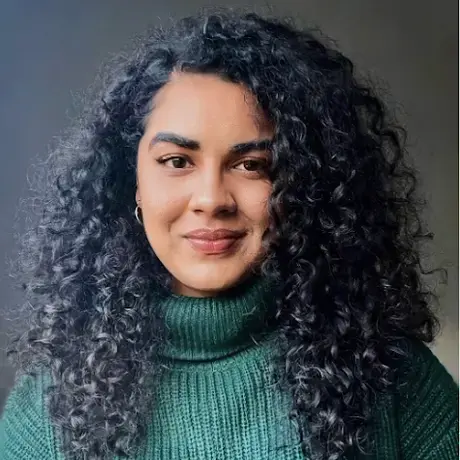 Headshot of Shradha wearing a green sweater
