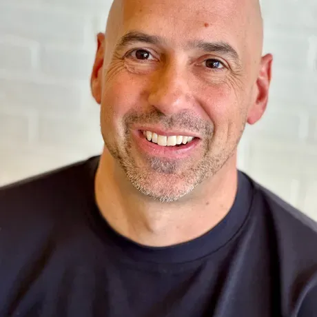 Headshot of Jim Garret, who wears a black t-shirt