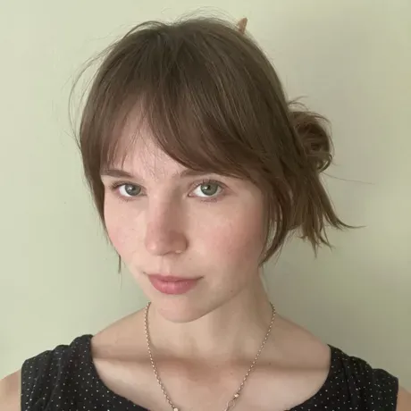 Headshot of woman with brown hair and sweeping bangs