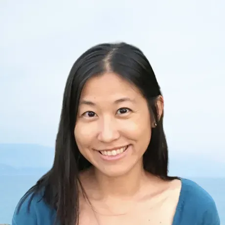 Yolanda Lau is an Asian woman with long Black hair smiling into the camera.