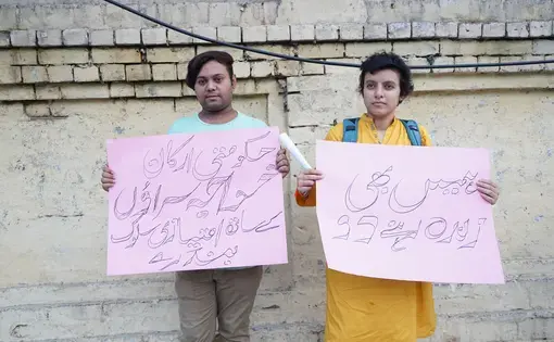 Two protesters, Sara and Sunny, holding signs in solidarity with the khawaja sira community.  Signs right to left read: "Let us live, too" and  "Government members, stop discriminating against khawaja siras." Image by Ikra Javed. Pakistan, 2016.