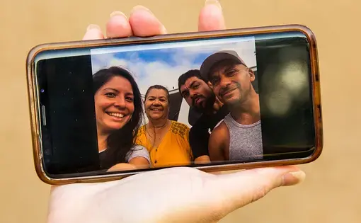Diana Zuñiga holds up a family photo taken at Terminal Island federal prison the day Carlos's dad was released after nearly 10 years in custody, and shortly before he was arrested and taken to Twin Towers Jail. Image by Arlene Mejorado/The Atlantic. United States, undated.