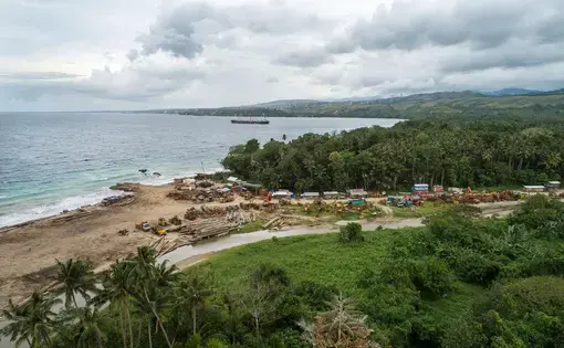 Logs are piled up on a beach, left there by a logging company. Moving single logs and equipment is often expensive, so companies will leave them at local sites. Image by Monique Jaques. Solomon Islands, 2020.