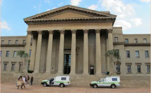 The Great Hall rests at the head of the central hub of the Braamfontein campus at the University of Witwatersrand. Many of the most remembered protests have taken place at university centers, and the Great Hall is no exception. Two police vehicles wait along with four others not pictured outside during the registration period. Image by Lorraine Pettit. South Africa, 2016.