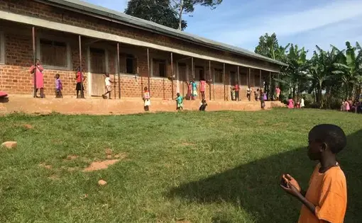 Students play in the school yard of a Building Tomorrow School as they wait to receive their report cards. Image by Brandon Posner. Uganda, 2016.