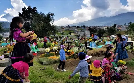 Local cemeteries come to life when families decorate the graves of their loved ones with candles, fresh cut grass, and flowers. For two days they pray, eat, and remember their ancestors in honor of Day of the Dead. Image by Kristian Hernandez. Guatemala, 2018.
