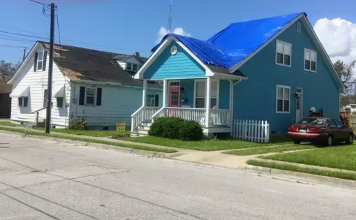 A home in Beaufort, North Carolina awaits roof repair. The tarp protects the home from further water damage. A shortage of contractors following the storm left many people waiting months for repairs. Image by Erika Layko. United States, 2018.