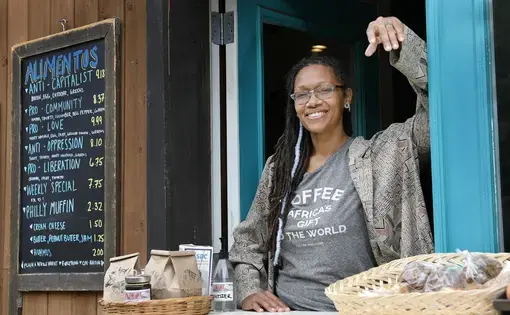 Blew Kind, owner of Franny Lou’s Porch Cafe &amp; Community Space, 2400 Coral St., Phila. Pa., was photographed at the cafe’s take out window on May 8, 2020. Image by Elizabeth Robertson / The Philadelphia Inquirer. United States, 2020.