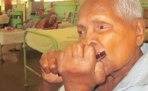 Gunathilike was sent to the Hendala Leprosy Hospital in 1946. He plays the mouth organ in the hospital band. Image by Ross Velton. Sri Lanka, 2015.