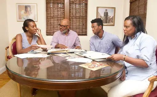 Caroline Washington with her father, Theo, brother Teddy, and mother, Denise as they go through family albums. The family members have been outspoken advocates for education and social justice over many generations. Image by Wiley Price. United States, 2019.