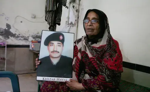 Iqbal Bano holds a photo of her son who is currently on death row in Lahore Central Jail.