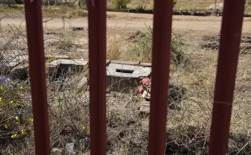 A ground pit latrine that has been gated off due to the immediate danger it posed to students at the Utjane Primary School in Limpopo. Image by Adam Yates. South Africa, 2018.