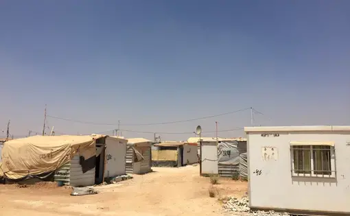 Za'atari Camp has now been open for over four years. Among its many developments, power lines and satellite dishes appear almost everywhere, connecting a sprawling jungle of caravans. Image by Rachel Townzen. Jordan, 2016.