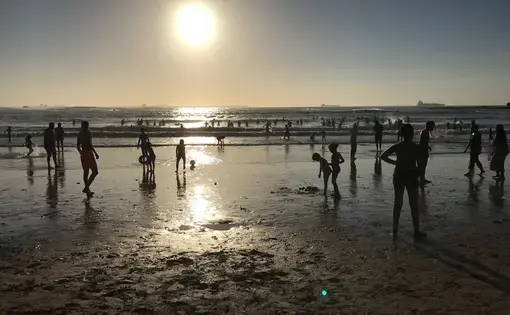 Visitors to the beach on the Atlantic Ocean in Mohammedia, Morocco, play in the surf as the sun sets. Morocco has emerged as a moderate leader admist the political and social turmoil of the rest of North African and the Middle East. Image by Jackie Spinner. Morocco, 2017.