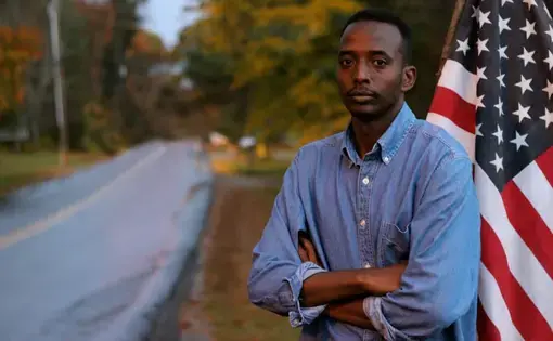 Abdi Nor Iftin in front of the U.S. flag. Image by Leo Hornak. United States, undated.