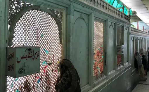 Women look through the jaali surrounding the courtyard of the dargah of Qutubuddin Bakhtiyar Kaki in Delhi.&nbsp;Image by Nikhil Mandalaparthy. India, 2019.