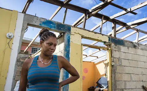 Rosalda Olma, a wife and mother to three kids, sorts through what remains of her home in Loiza.&nbsp;The entire home and contents were destroyed by the hurricane, and the family is living in a nearby school for the time being. “It’s hard getting used to these living conditions,” she said. “All five of us are trying to fit inside a single room.” Image by Ryan Michalesko. Puerto Rico, 2017.
