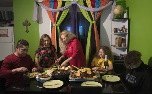 Ramon Flores, 46, from left, formerly of Hazel Dell, sits down to Thanksgiving dinner at his apartment in Tijuana, Mexico, with his daughter, Rayma, 10, wife, Enedis, 54, daughter, Kennedy, 16, and son, Raymond, 15. His family, who now lives in Chula Vista, Calif., crossed the U.S.-Mexico border shortly before midnight Wednesday so they could be together for the American holiday. Image by Amanda Cowan. Mexico, 2019.