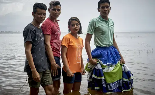 Dani and her friends on the banks of the Tapajós River standing in support of of LGBTQ+ rights. Image by Pablo Albarenga. Brazil, 2019.