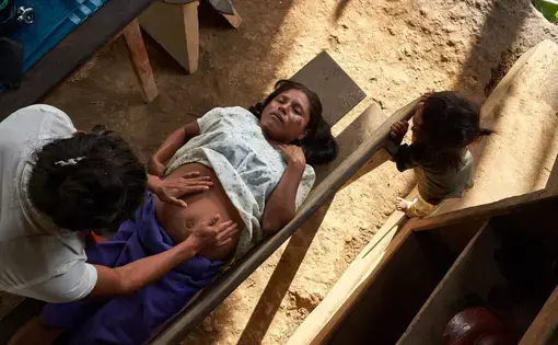 Vero controls the fetal position of a woman who is seven months pregnant. Image by Pablo Albarenga. Ecuador, undated.