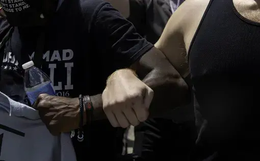 Two people link arms during a protest.