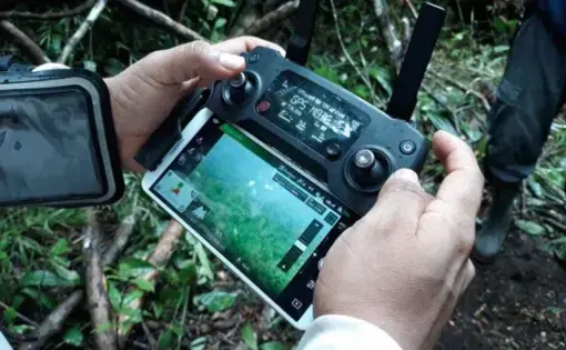 Two hands holding a control panel for an aerial drone.