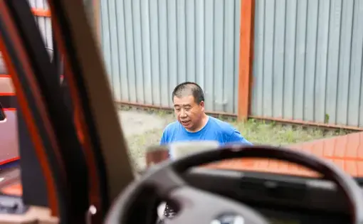 A view of Tom Tang through the dashboard of a truck.