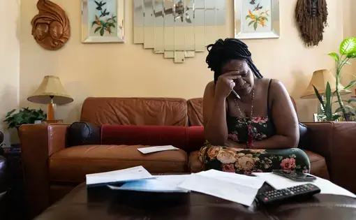 Woman sits with bills