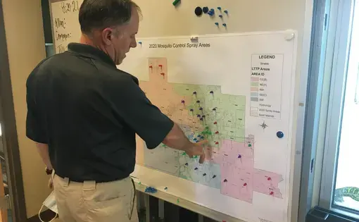 Scott Harrington, Calcasieu Parish Mosquito Control manager, in front of map