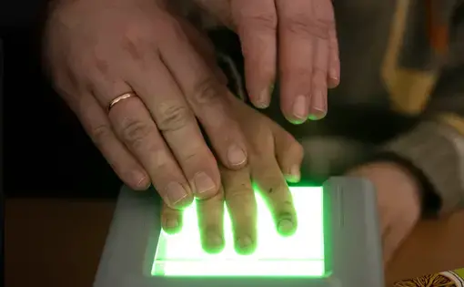 A child places his hand on a scanner