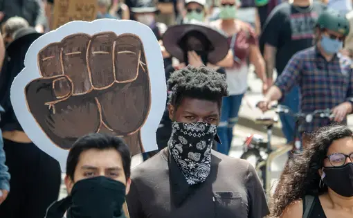 Individuals march in direction of photographer.