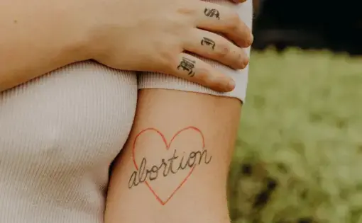 Makayla Montoya Frazier shows her tattoo that says “abortion” in a heart.