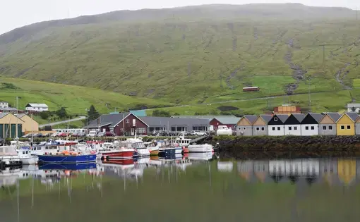 Fog hangs low over a harbor in Vestmanna. Image by Natasha Heisenberg. Faroe Islands, 2022.