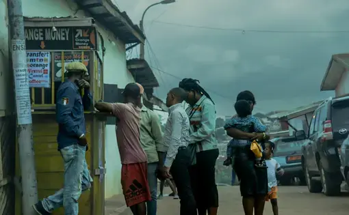 A small crowd queues up at one of Yaoundé's many yellow kiosks to transfer money, buy mobile data, or top off their credit.