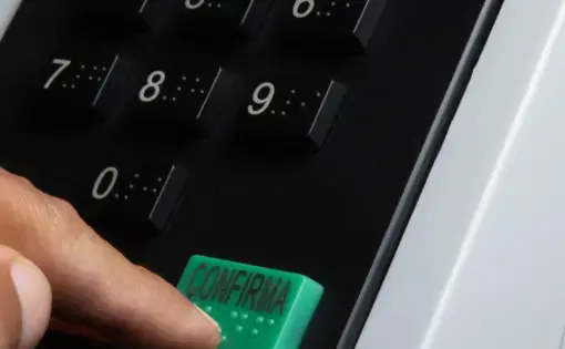 a man presses to confirm at an electronic voting system