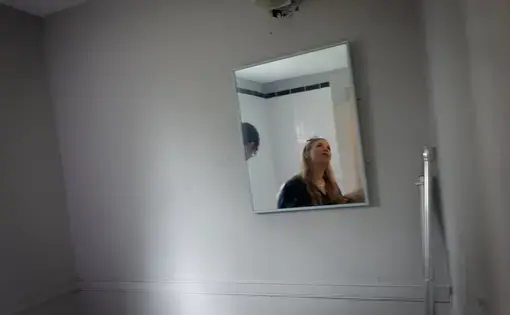 A looks away from a bathroom mirror.