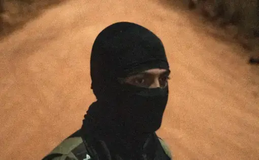 a man with a ninja mask in a diret road