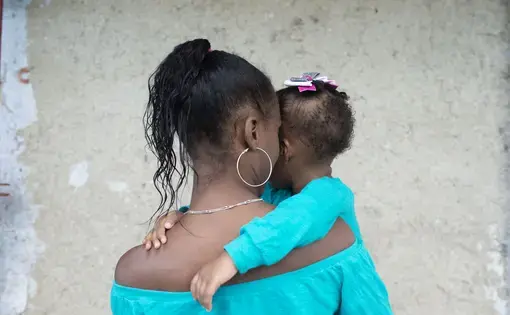 A woman and a baby from behind.
