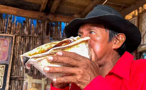 A man blows into a seashell