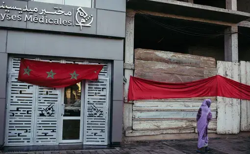 A person in a purple shawl walks past a medical clinic