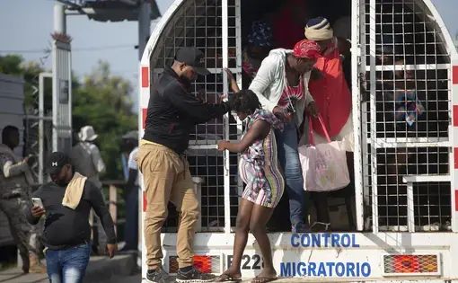 People alight from a barred truck