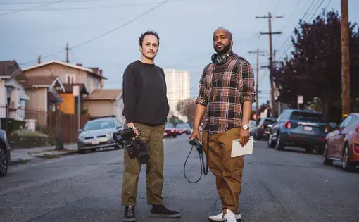 Grantees Brandon Tauszik and Pendarvis Harshaw stand in the street facing the camera.