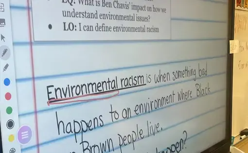 Picture of a smartboard with the definition of environmental racism displayed
