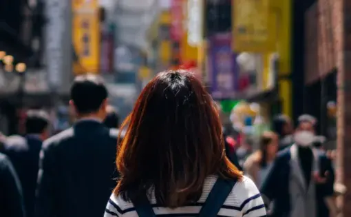 A person walking across through a busy arcade