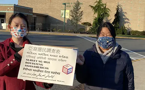 Two people hold up a sign