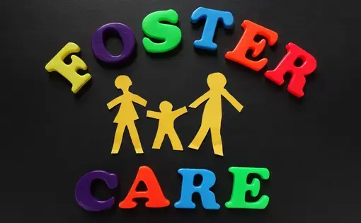 Graphic with black background and colorful letters that reads "foster care"
