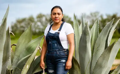 a woman worker stands in front of desert landscape