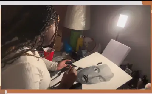 A student works on an illustration of Robert L. Carter.